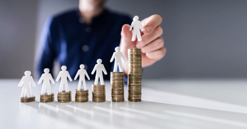 Des pièces de monnaies avec des petits bonshommes au-dessus représentant le calcul salarial
